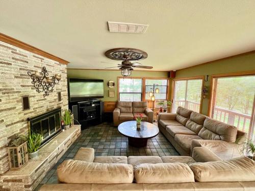 a living room with a couch and a fireplace at The River Haven - Sleeps 32 - on Guadalupe River in Seguin