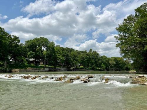 a river with rapids and rocks in the water at The River Haven - Sleeps 32 - on Guadalupe River in Seguin