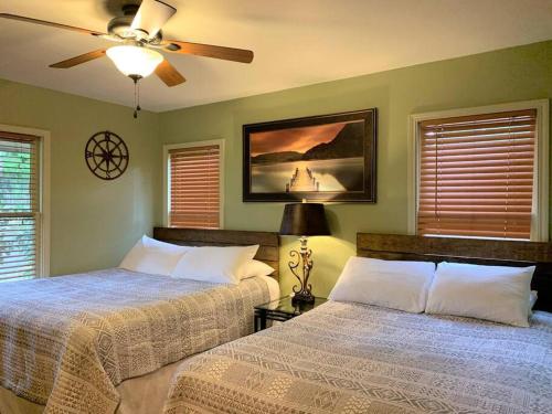 a bedroom with two beds and a ceiling fan at The River Haven - Sleeps 32 - on Guadalupe River in Seguin