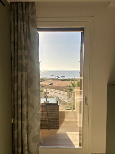 a door to a balcony with a view of the ocean at Residence Sunset Egadi in Marsala