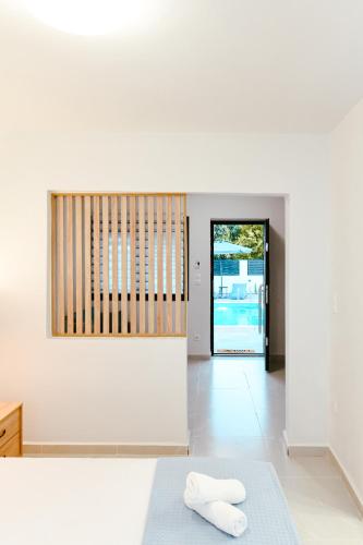a white room with two towels sitting on a bed at EliGio Luxury Suites in Asprovalta