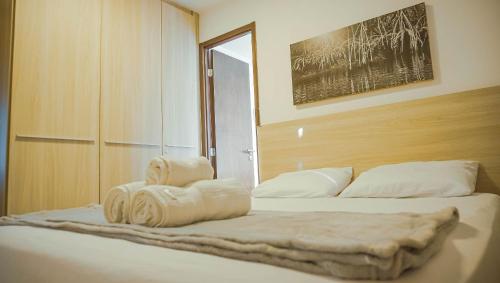 a bedroom with a bed with towels on it at Beach Class Convention - Flats em Boa Viagem por Yolo in Recife