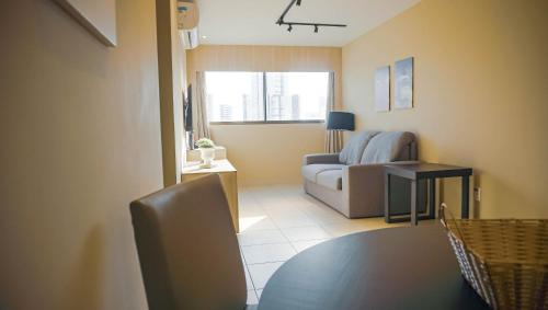 a living room with a table and a couch at Beach Class Convention - Flats em Boa Viagem por Yolo in Recife