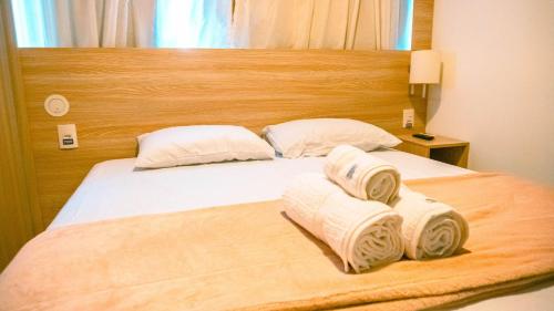 a bedroom with a bed with towels on it at Beach Class Convention - Flats em Boa Viagem por Yolo in Recife