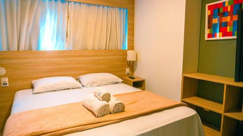 a bedroom with a bed with towels on it at Beach Class Convention - Flats em Boa Viagem por Yolo in Recife