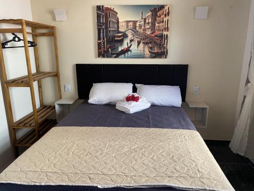 a bedroom with a bed with a painting on the wall at Pousada Vila Italia - Porto da Dunas in Aquiraz
