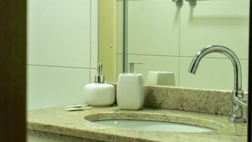 a bathroom sink with two soap dispensers on it at Beach Class Convention - Flats em Boa Viagem por Yolo in Recife