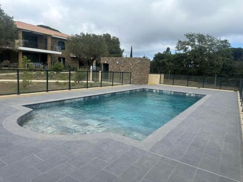 a swimming pool with blue water in front of a house at Clos d'Alice Villa 3 in Sainte-Maxime