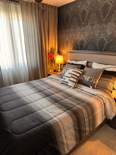 a bedroom with a large bed and a window at Z FamilyHome Suites & Apartments in Calgary