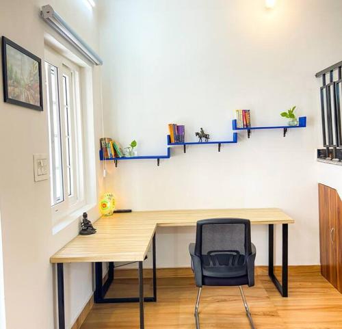 a desk in a room with a chair and shelves at Comfort & Cozy, Villa in Orchha