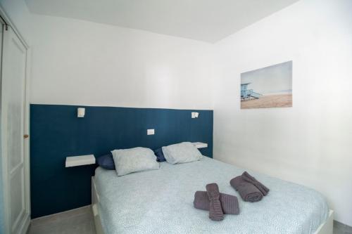 una camera da letto con un letto con due asciugamani marroni di El Nidito a Maspalomas