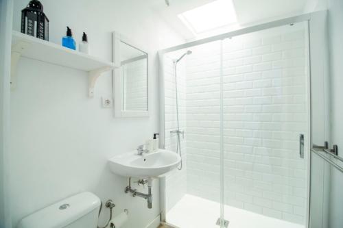 un bagno bianco con lavandino e doccia di El Nidito a Maspalomas