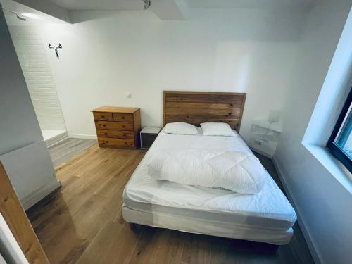 une chambre avec un lit avec une tête de lit en bois dans l'établissement Le centrale, à Lézignan-Corbières