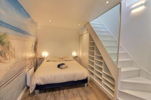 une chambre avec un lit et un escalier dans l'établissement Havre de paix & Jardin Quartier Bonsecours Fibré, à Trouville-sur-Mer