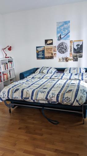 - un lit dans une chambre avec des affiches murales dans l'établissement Superbe Studio Fort d'Issy - Idéal professionnel ou vacancier, à Issy-les-Moulineaux