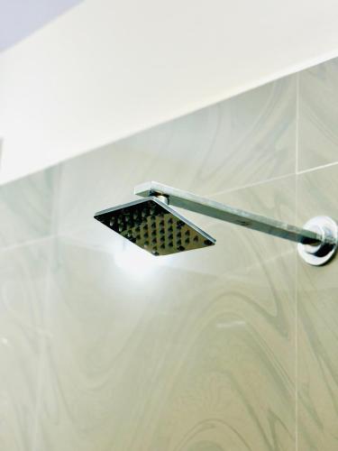 a shower with a shower head in a bathroom at SERENE POND RETREAT KOWDIAR 4bhk apartment in Trivandrum