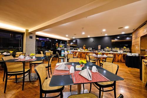 a restaurant with tables and chairs and a kitchen at Las Suites Campos Eliseos in Mexico City