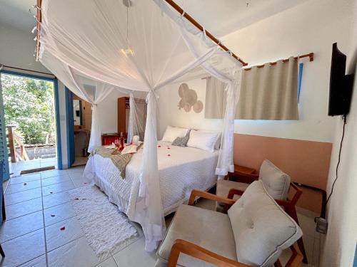 a bedroom with a white bed with a canopy at Pousada Sabina in Barra Grande