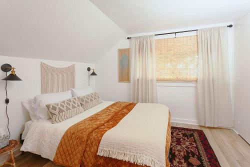 a white bedroom with a bed and a window at Classic & Cozy Apartments - Parking & Close To Dw in Medford