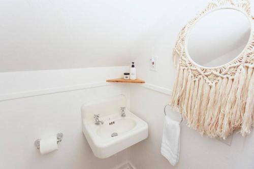 a white bathroom with a sink and a mirror at Classic & Cozy Apartments - Parking & Close To Dw in Medford
