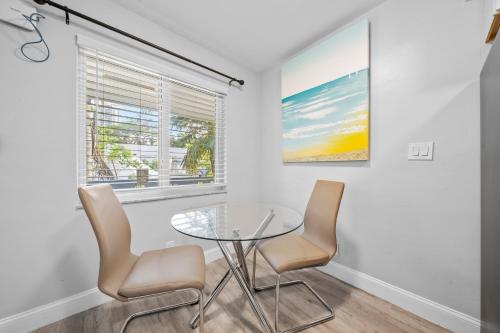 a dining room with a glass table and two chairs at Riverbend Apartments by Lowkl in Fort Lauderdale