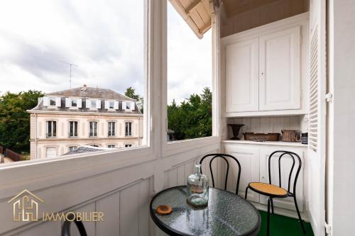 une table et des chaises sur un balcon avec vue sur un immeuble dans l'établissement Le Premium - Parking City Center, à Colmar