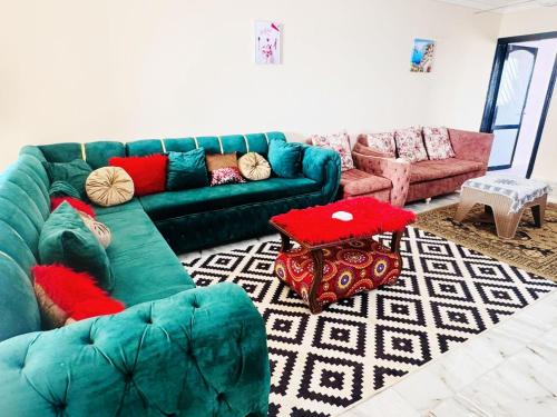 a living room with a green couch and two couches at قرية منيه فايد in ‘Ezbet Hasan Sallâm