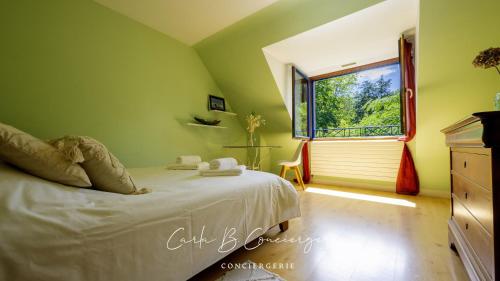 une chambre verte avec un lit et une fenêtre dans l'établissement LA ROSE DES VENTS - CONCARNEAU - 8 personnes, à Concarneau
