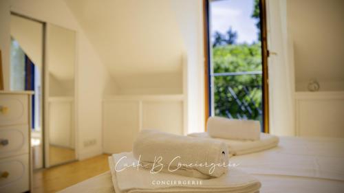 Cette chambre blanche dispose d'une chaise et d'une fenêtre. dans l'établissement LA ROSE DES VENTS - CONCARNEAU - 8 personnes, à Concarneau