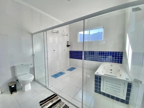 a bathroom with a glass shower and a toilet at Sua Casa em Maresias I in São Sebastião