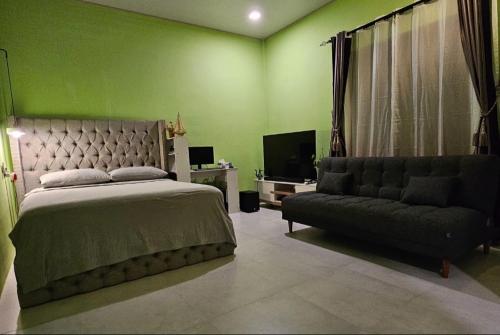 a bedroom with a bed and a couch at Iruka Guesthouse in Faresmathoda