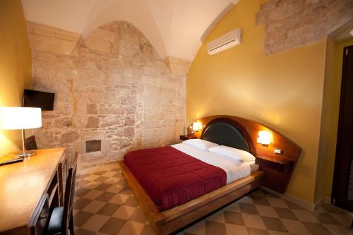 a bedroom with a bed with a stone wall at B&B Residenza Pizziniaco in Lecce