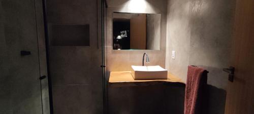 a bathroom with a sink and a mirror at Studio Pitanga - Vale do Capão - Caeté Açu - in Vale do Capao