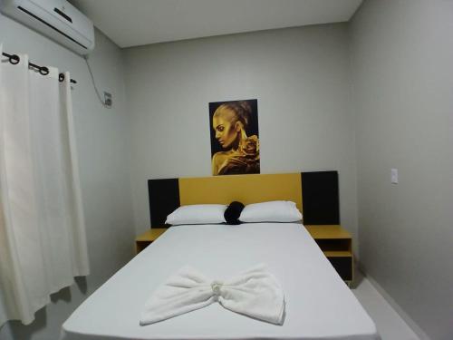 una camera da letto con un letto con un arco sopra di FLAT Residencial Caribe a Confresa