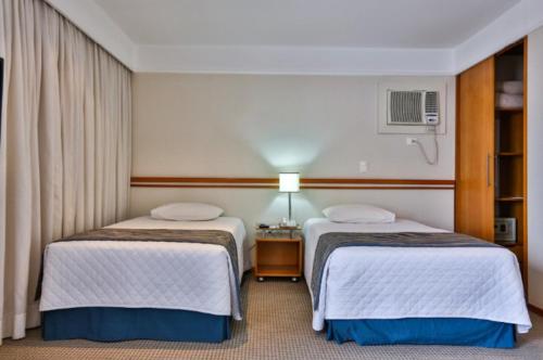 a hotel room with two beds and a window at Transamerica Executive Sorocaba in Sorocaba