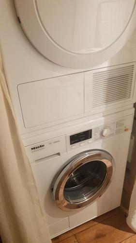 eine weiße Waschmaschine und ein Trockner in einem Zimmer in der Unterkunft Chalet Les Bouvreuils La Bresse Haute Vosges in La Bresse