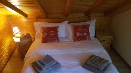 ein Schlafzimmer mit einem großen weißen Bett mit roten Kissen in der Unterkunft Chalet Les Bouvreuils La Bresse Haute Vosges in La Bresse