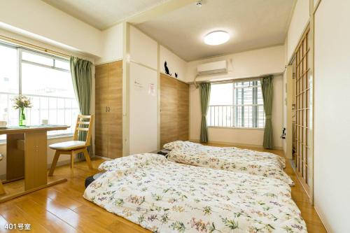 a bedroom with two beds and a desk and window at Nanei Building - Vacation STAY 47375v in Kagoshima