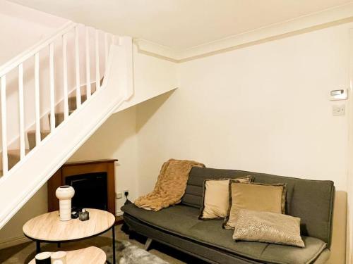 a living room with a green couch and a staircase at Simple House w- FREE PARKING by Manchester Airport - FREE DROP-OFF in Manchester