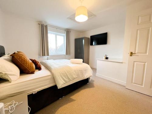 a bedroom with a bed and a television in it at Simple House w- FREE PARKING by Manchester Airport - FREE DROP-OFF in Manchester