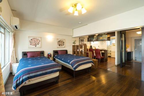 a bedroom with two beds and a dining room at Nanei Building - Vacation STAY 47392v in Kagoshima