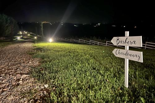 a street sign in the grass next to a road at Notte nella Botte in Vignale Monferrato