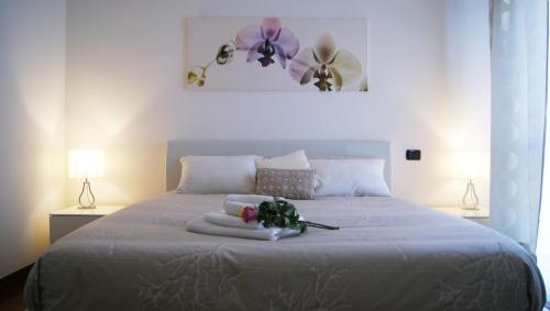 フィウミチーノにあるCatia Sweet Holiday 2のベッドルーム1室(花が咲く白いベッド1台付)
