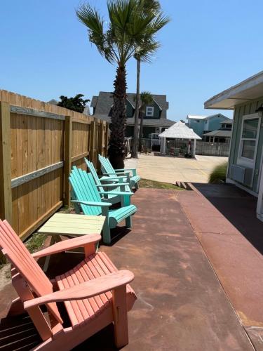 a row of chairs sitting next to a fence at Seashell Village Resort near the beach with kitchens in Port Aransas