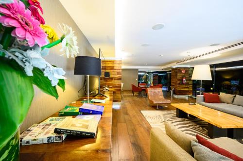 a living room with a couch and a table with flowers at Las Suites Campos Eliseos in Mexico City