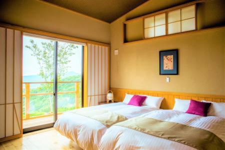 a bedroom with two beds and a large window at TOKI Resort HAKONE BETTEI in Hakone