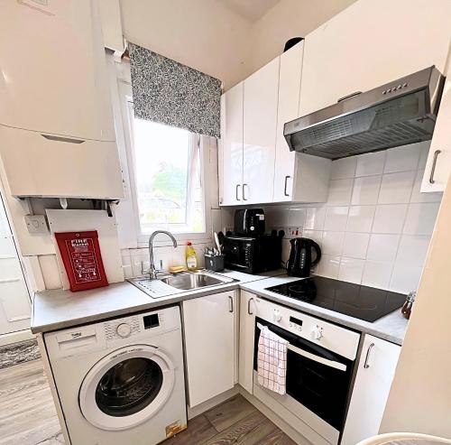 eine Küche mit Waschmaschine und Spüle in der Unterkunft NEW Spacious 6 Guests House Sheffield WIFI Parking in Ecclesfield