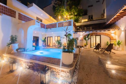 a villa with a swimming pool in a courtyard at Casa Victoria Malecón - Adults Only in Puerto Vallarta