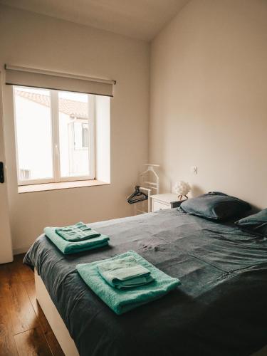 - une chambre avec un lit et des serviettes vertes dans l'établissement La bodeguita 1, à Saint-Génis