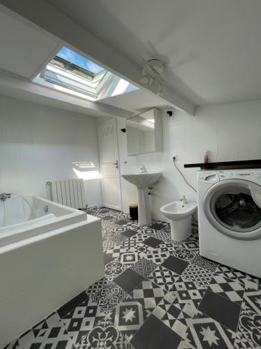 une salle de bain avec machine à laver et toilettes dans l'établissement Haut de villa avec vue mer et terrasse, à La Ciotat